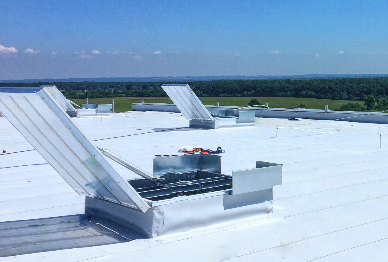 Otwarta klapa dymowa na dachu hali przemysłowej podczas testu systemu