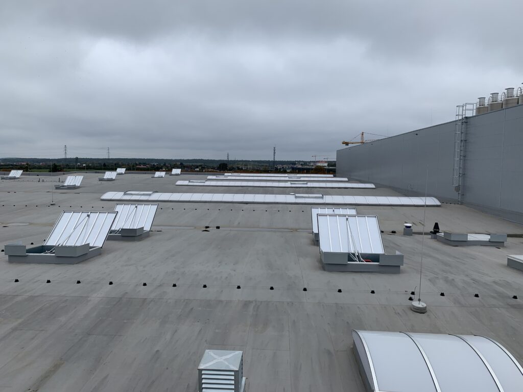 Klapy dymowe na dachu hali przemysłowej – element systemu oddymiania także w klatkach schodowych